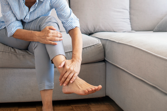 WebReady Product-STK_woman on couch holding her leg_ECNE.png